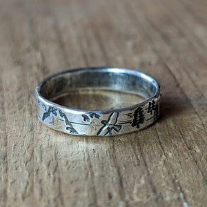 Nature-Inspired Sterling Silver Forest Ring depicting mountains, trees, and birds on a wide rustic band.