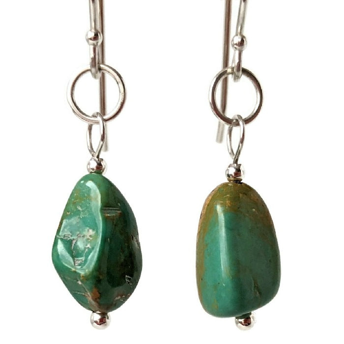 A pair of Kingman turquoise and Sterling Silver earrings hangs in the Danare Designs jewelry Studio.