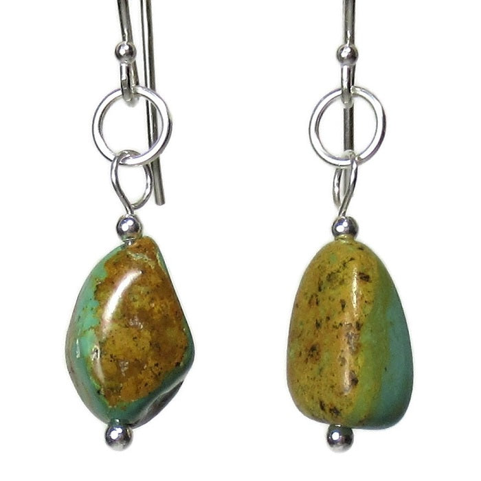 A pair of Kingman turquoise and Sterling Silver earrings hangs in the Danare Designs jewelry Studio.