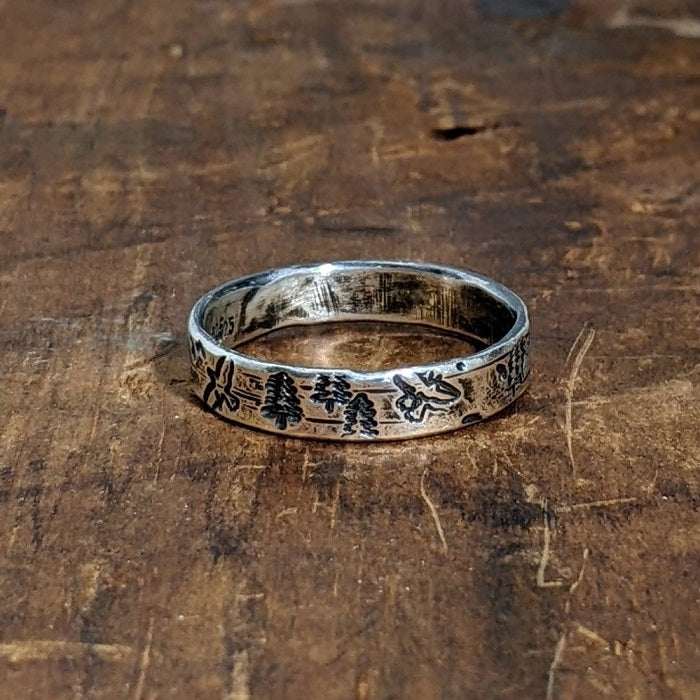 Nature-Inspired Sterling Silver Forest Ring depicting mountains, trees, and birds on a wide rustic band.